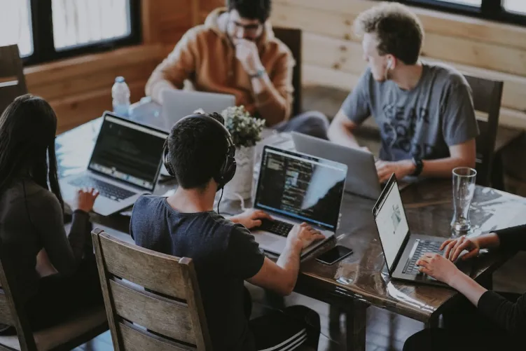 People on laptops around a table