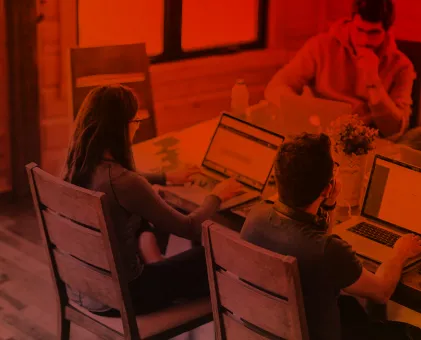 People sat around a table on laptops